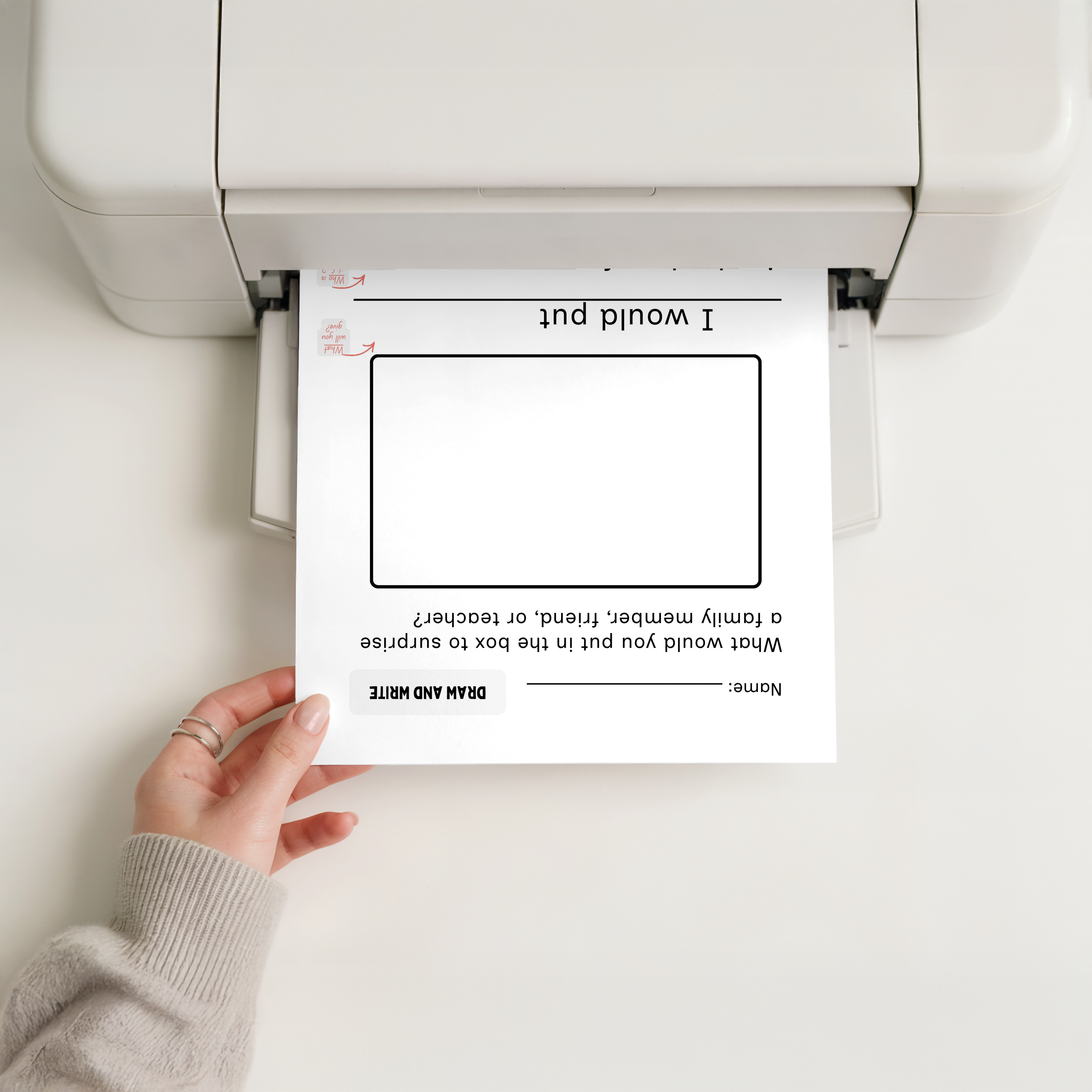 Hand holding a printed worksheet in front of a printer